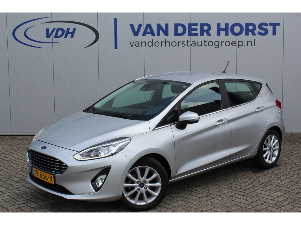 Ford Fiesta 1.0-100pk EcoBoost Titanium 5drs. Uiterst nette, luxe en zuinige Ford Fiesta. Voalautm. airco, Cruise control, Navigatie, LM wielen, Metallic lak, Parkeersensoren achter, Telefoonvoorb., Lane assist etc.
