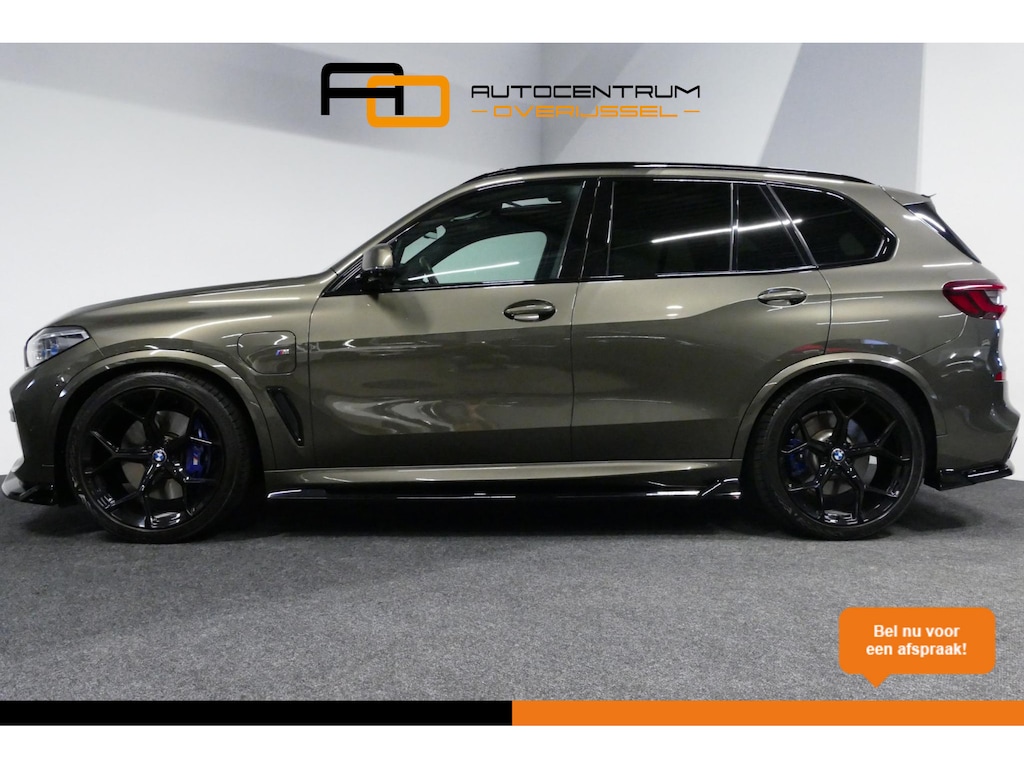 BMW X5 xDrive45e M Sport / Orig. Nederlands / Maxton Design Bodykit V.2 / Panoramadak Sky Lounge / Massage stoelen / Carbon inleg / Trekhaak / Elektr. verstelbare voorstoelen + memory / BMW Laser Koplampen / Bowers & Wilkins Sound-system / Head-up Display / Achterasbesturing / Stoelverwarming & -koeling / Bekerhouder met verwarm- & koelfunctie / Softclose - servosluiting / Ambienteverlichting / Shadow-Line