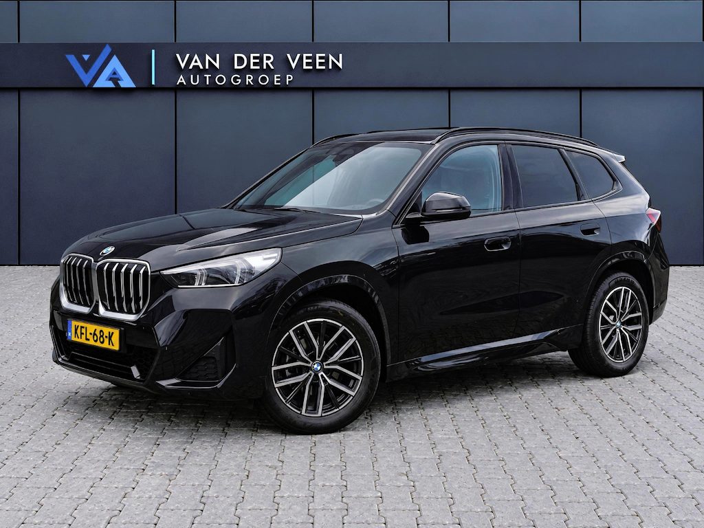 BMW X1 sDrive18i M-Sport | Panorama dak | Elektrisch wegklapbare trekhaak | Stoelverwarming | Achteruitrijcamera | Elektrische kofferbakklep | Keyless entry/start | Half leder/alcantara | Draadloze telefoonlader | Apple CarPlay/Android Auto | Navigatie | Climate controle | Parkeersensoren V+A |