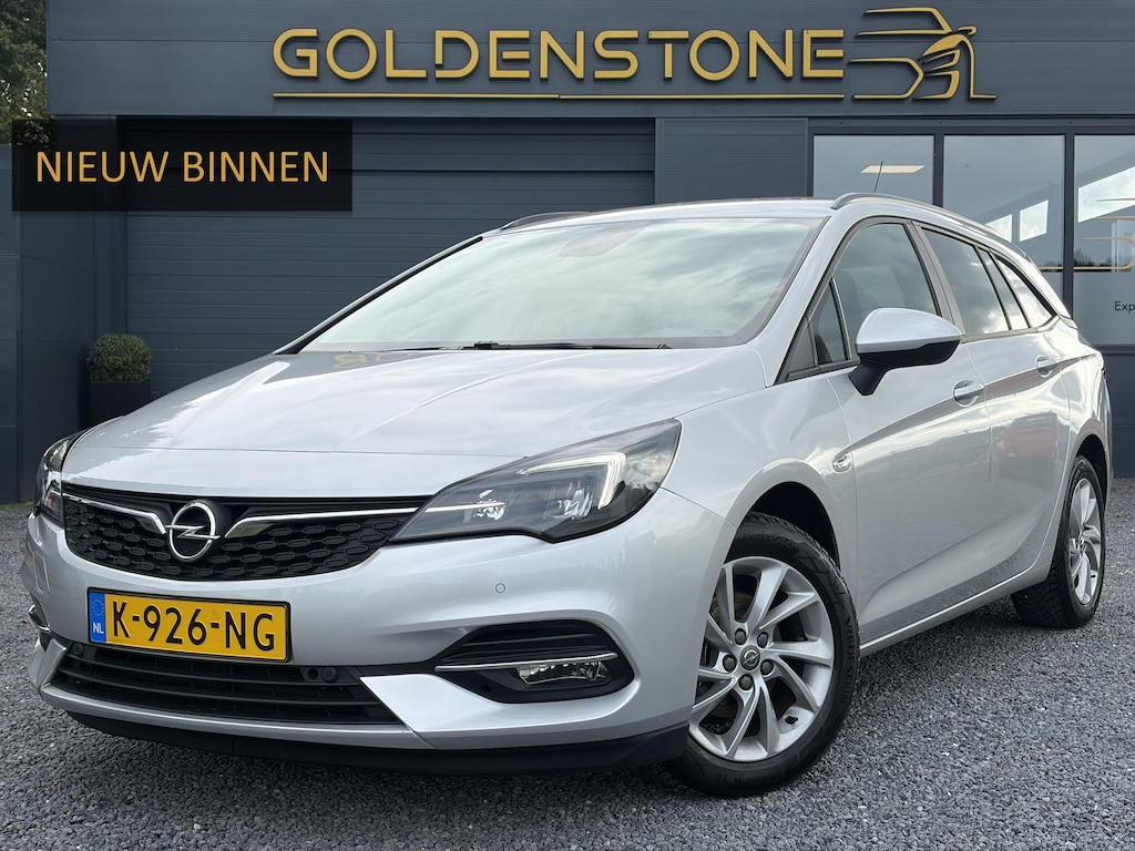 Opel Astra Sports Tourer 1.2 Business Executive ✓1e Eigenaar✓146pk✓Camera✓Trekhaak✓Carplay✓Airco✓Cruise✓Pdc V+A✓Lm velgen✓Comfortstoelen✓6 Bak✓N.A.P✓Nieuwe Apk bij Aflevering