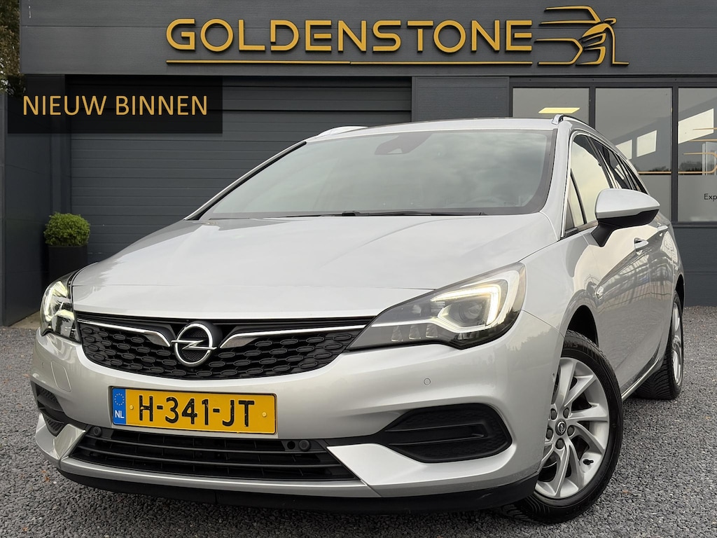 Opel Astra Sports Tourer 1.2 Elegance ✓110pk✓Camera✓Carplay✓Navi✓Halfleder✓Keyless✓Trekhaak✓Pdc V+A✓Clima✓Cruise✓Elekt Stoel✓Recent beurt gehad✓Dodehoeksensor✓Rijstrooksensor✓Lm velgen✓N.A.P✓Apk tot 11-2027