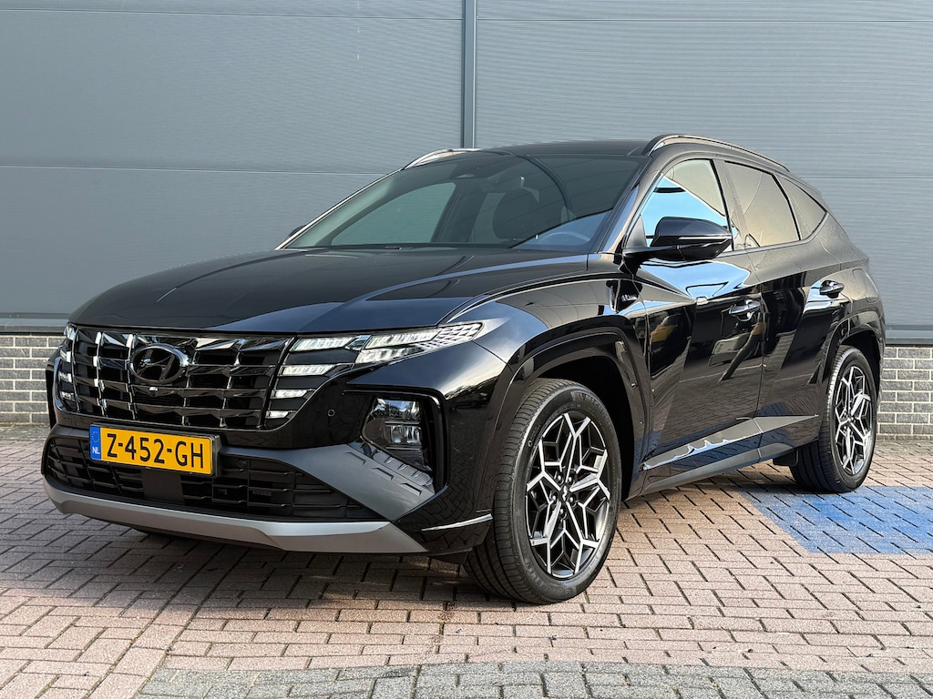 Hyundai Tucson 1.6 T-GDI PHEV N Line Sky 4WD / Panoramadak / 360° camera / Adaptive cruise control / Stoelventilatie / Stoelverwarming voor + achter / Stuurwielverwarming / Elektrisch verstelbare voorstoelen / Elektrische achterklep / Keyless entry & start / Apple CarPlay & Android Auto / Navigatie / Draadloos telefoonladen / LED verlichting / 19” N Line velgen / Dodehoekdetectie / Parkeersensoren voor + achter / Climate control / Privacy glass / N Line interieur & exterieur