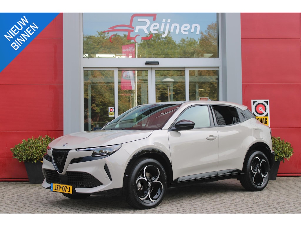 Alfa Romeo Junior 1.2 145PK AUTOMAAT Hybrid IBRIDA TI | TECHNO PACK: (LED MATRIX KOPLAMPEN, DRAADLOZE TELEFOONLADER, DODEHOEK DETECTIE, PARKEERSENSOREN VOOR ACHTER EN ZIJKANT, NAVIGATIE, ELEKTRISCH BEDIENBARE ACHTERKLEP, KEYLESS ENTRY, ADAPTIVE CRUISE CONTROL, ACHTERUITRIJ CAMERA) | PACK TI: (ELEKTRISCH BEDIENBARE BESTUUDERSSTOEL, VERKEERSBORDEN WEERGAVE, GETINTE ACHTERRUITEN, SFEER VERLICHTING, GLANZEND ZWARTE BODYKIT, 10,25" TOUCHSCREEN, LEDEREN STUURWIEL, VERSTELBARE KOFFERVLOER OP 3 NIVEAUS) | 18" LICHTMETALEN VELGEN "FORI" | DRAADLOZE APPLE CARPLAY/ANDROID AUTO | MASSAGE FUNCTIE OP DE BESTUURDERSSTOEL | STOEL VERWARMING | VOORRUIT VERWARMING |