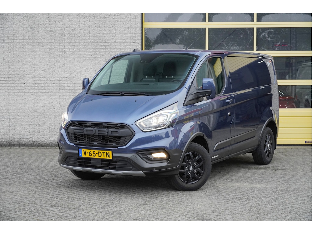 Ford Transit Custom 300 2.0 TDCI L1H1 Trail BJ2022 Lmv 16" (Zwart) | Led | Pdc | Trekhaak | Verwarmde voorruit | Achteruitrijcamera | Navi | Airco | Cruise control | Lederen bekleding | Verwarmde voorstoelen | Tussenschot | Achterdeuren | Zijdeur | Bijrijdersbank|3 Persoons