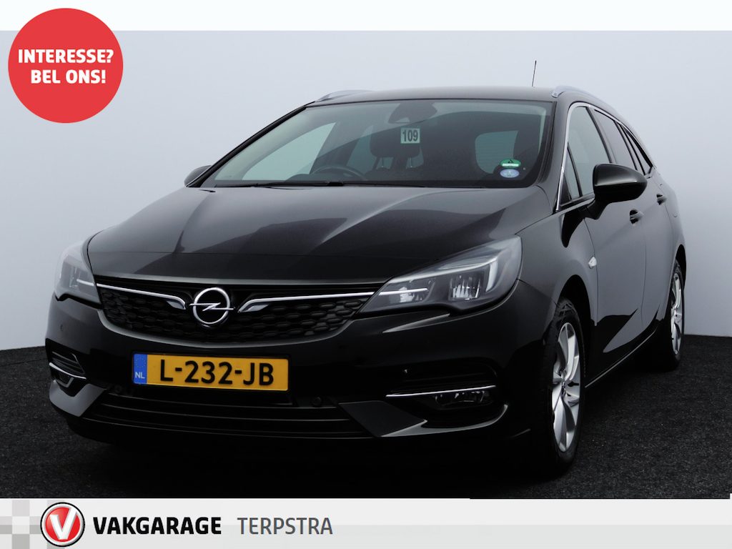 Opel Astra Sports Tourer 1.2 Elegance/ Trekhaak/ 16'' LMV/ LED Koplampen!/ Stoel + Stuurverw./ Camera/ Apple + Android/ Half-Leder/ Dode-Hoek DET./ Extra getint glas/ PDC V+A/ Navi/ Clima/ Cruise/ Bluetooth.