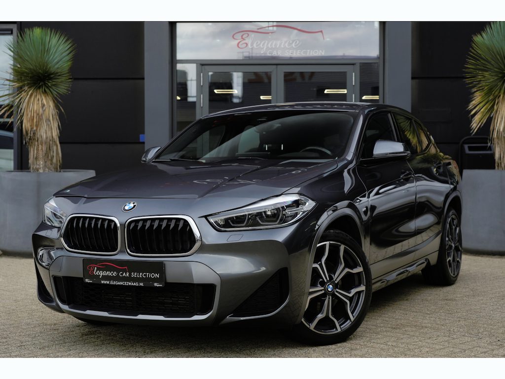 BMW X2 sDrive18i M Sport High Executive | 136 PK | HUD | Navigatie | Adaptieve cruise control | Stoelverwarming | BMW X2 sDrive18i M Sport High Executive met 136 PK uit een 1.5-liter driecilinder benzinemotor, voorzien van lederen/microvezel bekleding, verwarmde sportstoelen, automatische 2-zone climate