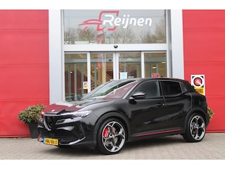 Alfa Romeo Junior Elettrica VELOCE 280PK 54 kWh | SPORT PACK (SABELT SPORTSTOELEN ELEKTRISCH BEDIENBAAR OP DE BESTUURDERSSTOEL/STOEL VERWARMING/ALUMINIUM INSTAPLIJSTEN EN PEDALEN/PERFROMANCE STUURWIEL MET ALCANTARA/PERFORMANCE BODYKIT "PROGRESSO"/AMBIENT LIGHT/GETINTE ACHETRRUITEN | TECHNO PACK (LED MATRIX KOPLAMPEN/AUTOMATISCH DIMMENDE BINNENSPIEGEL/DRAADLOZE TELEFOONLADER/DODEHOEK DETECTIE/NAVIGATIE/ELEKTRISCH BEDIENBARE ACHTERKLEP/KEYLESS ENTRY/KEYLESS START/ADAPTIVE CRUISE CONTROL/ACHTERUITRIJ CAMERA) | DRAADLOZE APPLE CARPLAY/ANDROID AUTO | 20" LICHTMETALEN VELGEN "VENTI" | RODE REMKLAUWEN | DC SNELLADER | "TORSEN" SPERDIFFERENTIEEL | GROTERE REMSCHIJVEN VOOR |