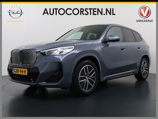 BMW iX1 eDrive20 67kWh M Sport pakket Pano-Dak/Schuif-dak Leer SOH 100% Warmtepomp Camera Navi Ecc PDC-a+v Apple Carplay Android Auto Elek.Achterklep Zwarte-Hemel VerkeersbordHerkenning WiFi M Aerodynamica  Lmv Led Privacy Glas Isofix DAB Keyless Wifi 1e Eigenaar Origineel Nederlandse Auto !!