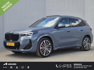 BMW X1 xDrive30e 326 PK M-SPORT / Fabrieksgarantie tot 03-2028 / Glazen schuif- en kanteldak / Head Up Display / Elektrisch trekhaak / Trekgewicht 1800 kg / Harman Kardon Audio Systeem / Elektrische achterklep / Rondomzicht camera / Stuur- & Stoel verwarming / Adaptief cruise control /