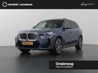 BMW iX1 eDrive20 67 kWh | M-Pakket | SOH 98% | Harman/Kardon | Ele. verstelbare stoelen + Geheugen | Panoramdak | Sportstoelen | Curved Display | 360 Camera | Trekhaak | HUD |
