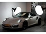 Porsche 911 Cabrio 3.8 Turbo 441kW/600pk PDK7 NL-AUTO!! AKRAPOVIC COMPLEET + SPORT CHRONO + PDLS PLUS + KEYLESS DRIVE + PASM + CAMERA + STOELVERWARMING&-VENTILATIE + BOSE SOUND + TARGET BLUEYE + MOSHAMMER SPOILERPAKKET + PARKSENSOREN V&A + 20" VOSSEN LM-VELGEN!