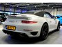 Porsche 911 Cabrio 3.8 Turbo 441kW/600pk PDK7 NL-AUTO!! AKRAPOVIC COMPLEET + SPORT CHRONO + PDLS PLUS + KEYLESS DRIVE + PASM + CAMERA + STOELVERWARMING&-VENTILATIE + BOSE SOUND + TARGET BLUEYE + MOSHAMMER SPOILERPAKKET + PARKSENSOREN V&A + 20" VOSSEN LM-VELGEN!