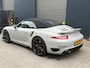 Porsche 911 Cabrio 3.8 Turbo 441kW/600pk PDK7 NL-AUTO!! AKRAPOVIC COMPLEET + SPORT CHRONO + PDLS PLUS + KEYLESS DRIVE + PASM + CAMERA + STOELVERWARMING&-VENTILATIE + BOSE SOUND + TARGET BLUEYE + MOSHAMMER SPOILERPAKKET + PARKSENSOREN V&A + 20" VOSSEN LM-VELGEN!