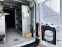 Ford E-Transit 350 L3H2 Trend 68 kWh Kastinrichting Werkplaatsinrichting Airco Cruise controle 360° Camera Navigatiesysteem Telefoonverbinding Parkeersensoren voor en achter 2-Persoons Oplaadkabels Stoelverwarming Bottinrichting